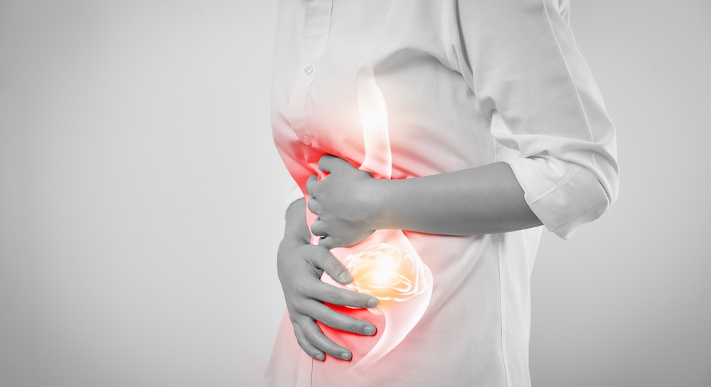Woman hands touching belly and stomach painful suffering from ulcerative colitis on white background.