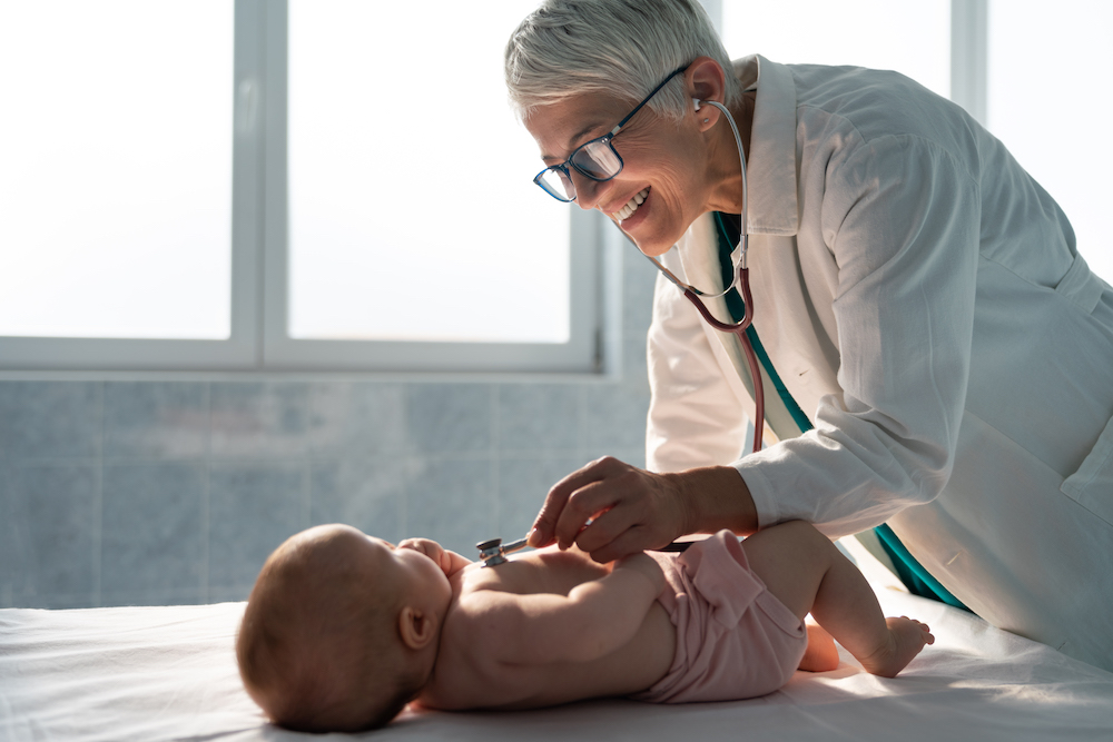 Happy pediatric doctor exams little baby. Health care, medical examination, people concept paediatrics online consultation