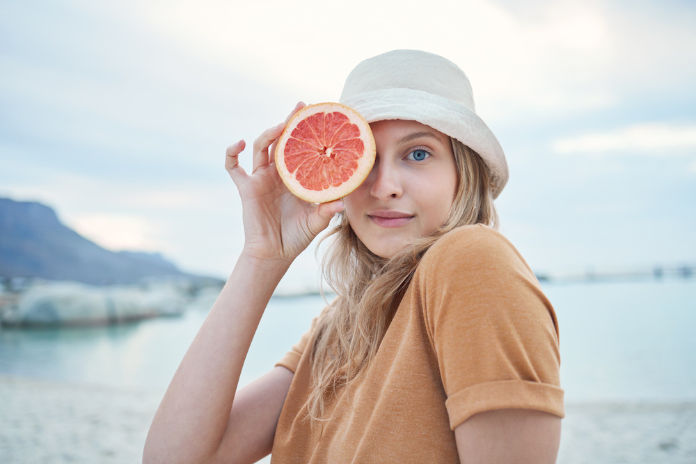 Grapefruit, wellness and woman on tropical beach for nature holiday, vacation or outdoor vitamin c . cairns telehealth service